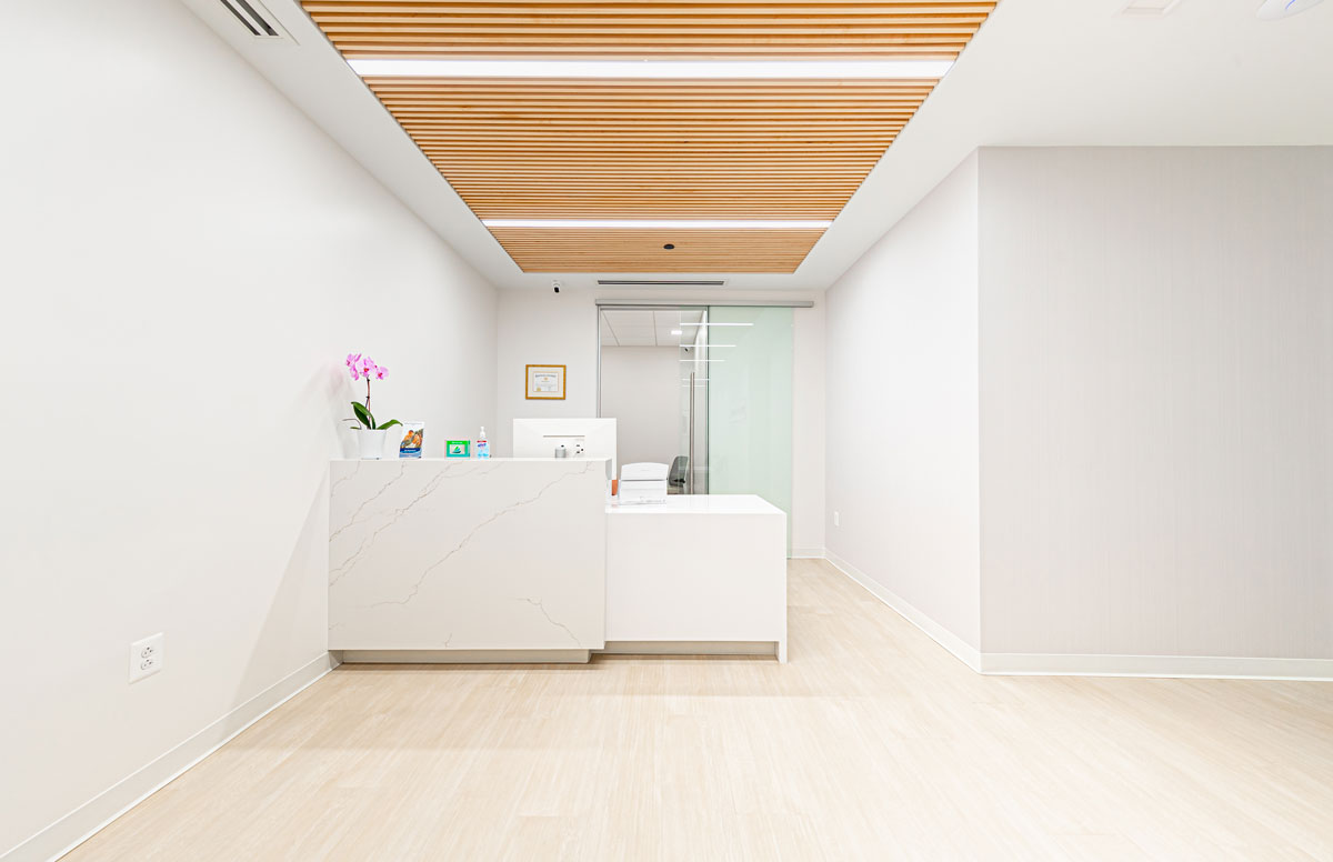 Modern reception desk at Project Dental in Rockville, MD with wooden ceiling panels